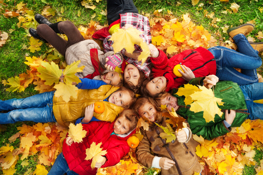 kids in fall leaves at family friendly picnic