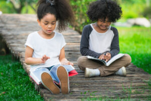 Kids outdoors in summertimne reading