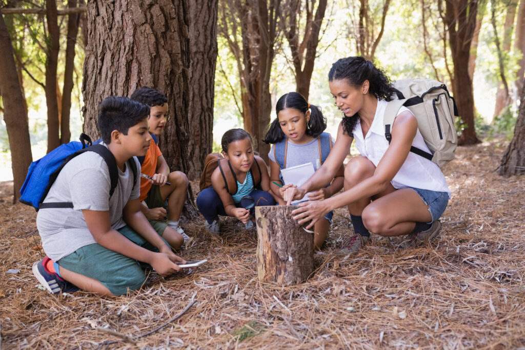 Teacher and children explore nature during spring nature walk