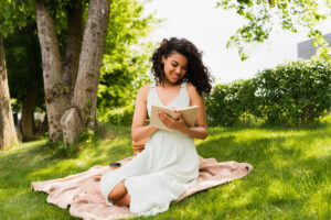 happy girl outdoors reading spring-themed book