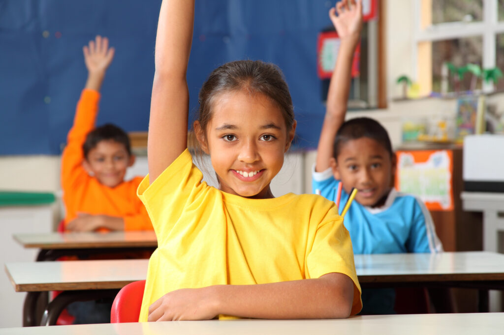 students with hands raised