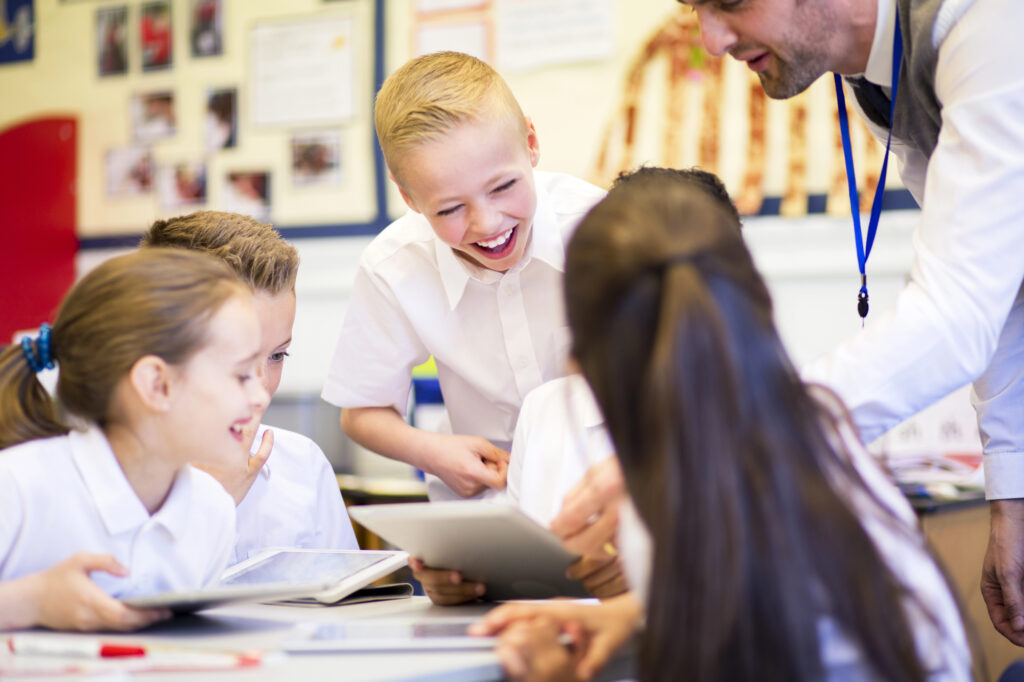 Teacher and students using social media game in classroom 