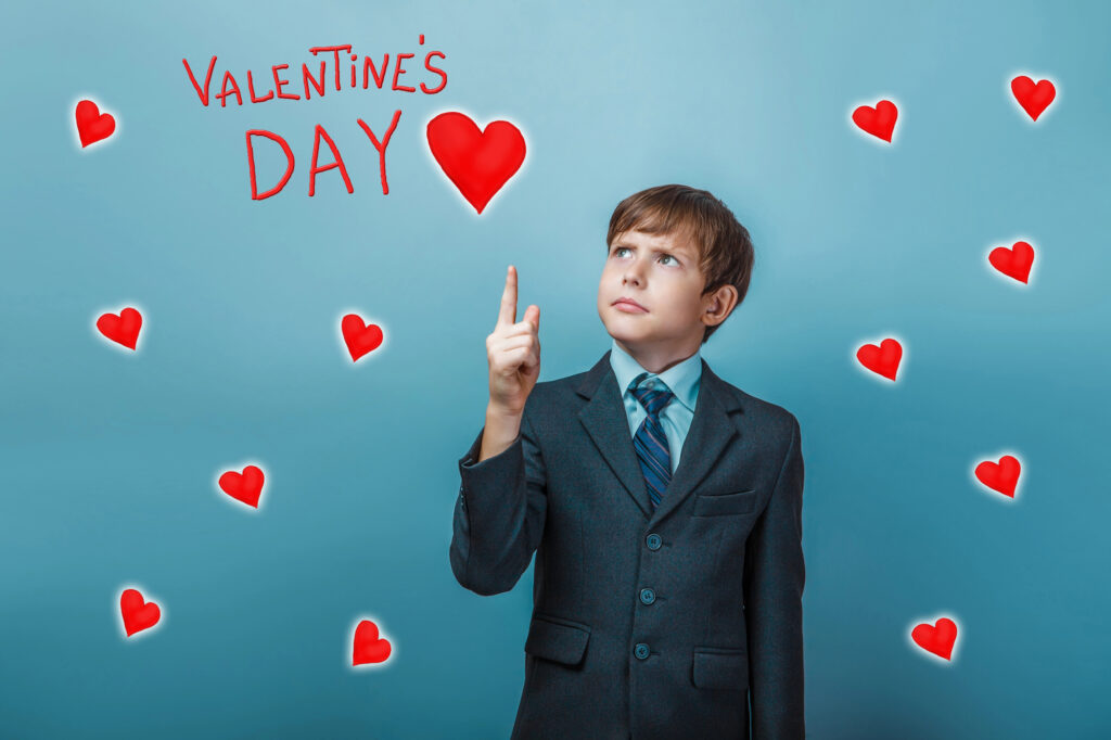 Young boy pointing toward the words "Valentine's Day"